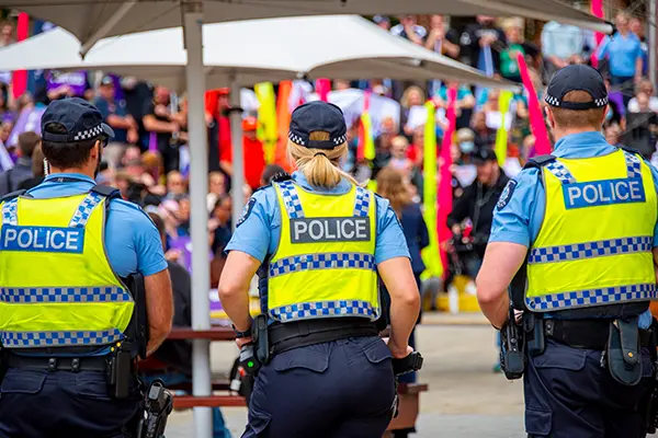 Police officers in high-visibility vests at public event, equipped with Motorola tactical audio gear