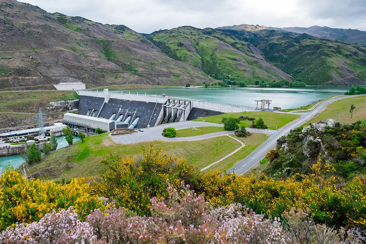 Hydroelectric dam in mountainous region with reservoir and surrounding infrastructure