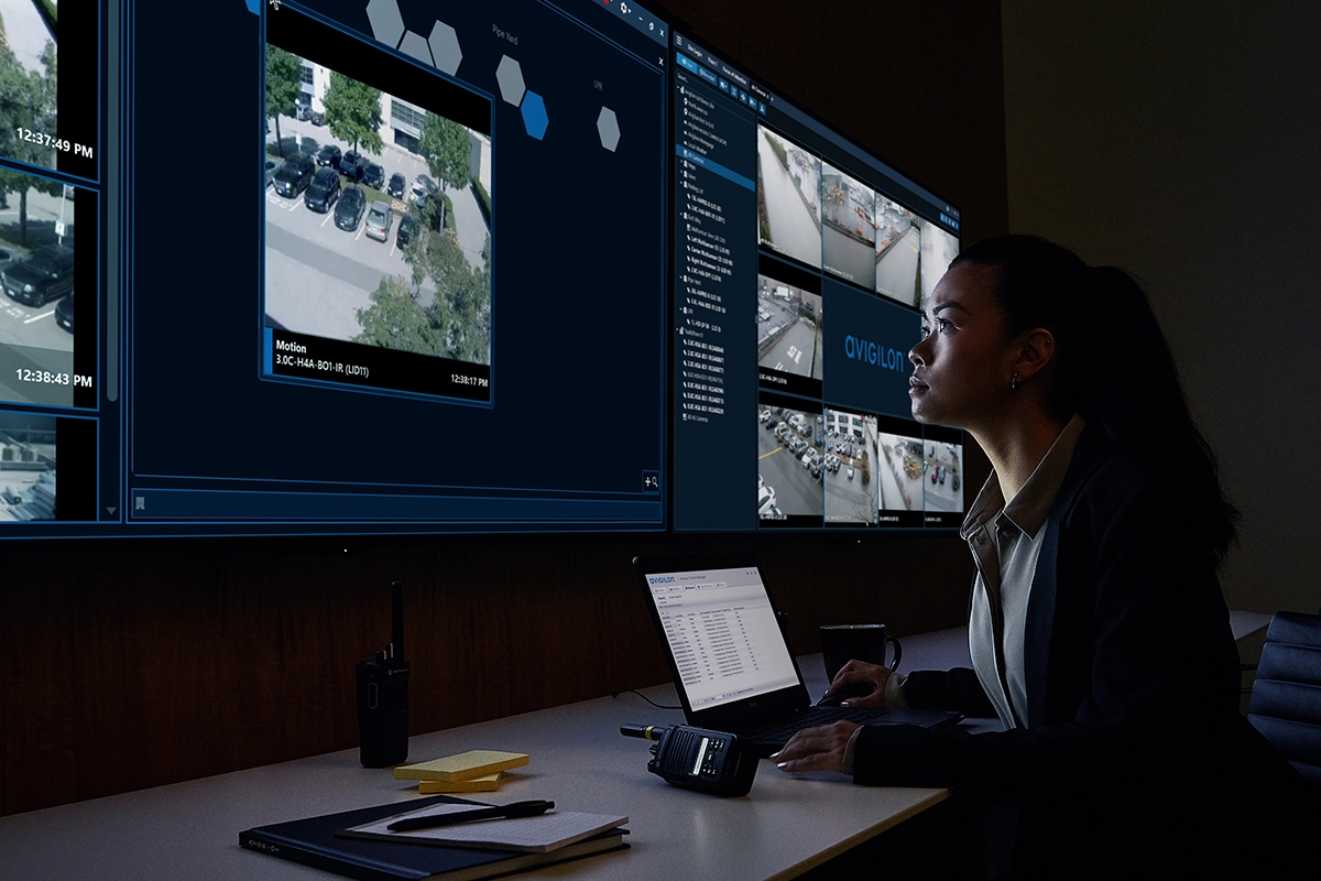 A desk setup with multiple Avigilon surveillance screens, a laptop and office supplies, representing Logic Technologies’ collaborative approach to delivering integrated Motorola Solutions technology.