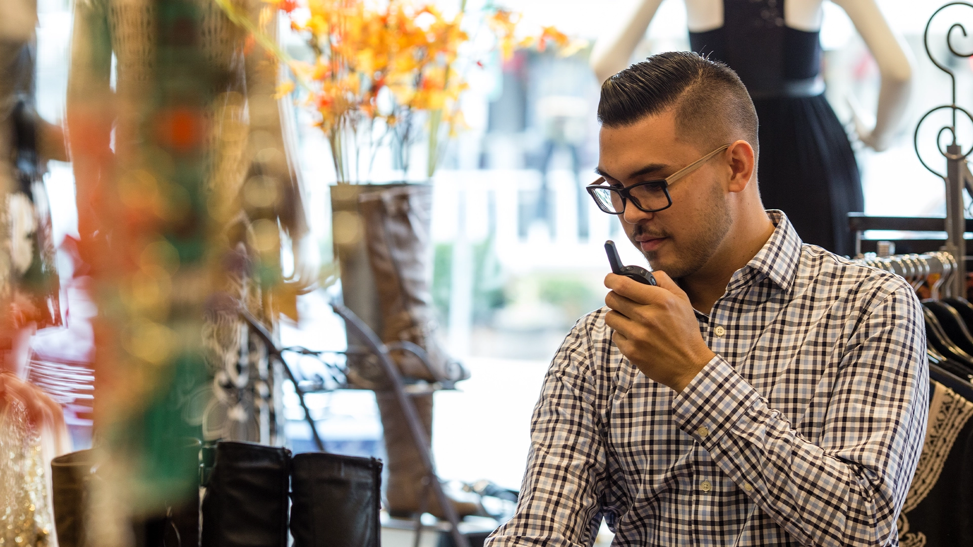 Retail worker communicating with the team using a Motorola Solutions Curve Two Way Radio